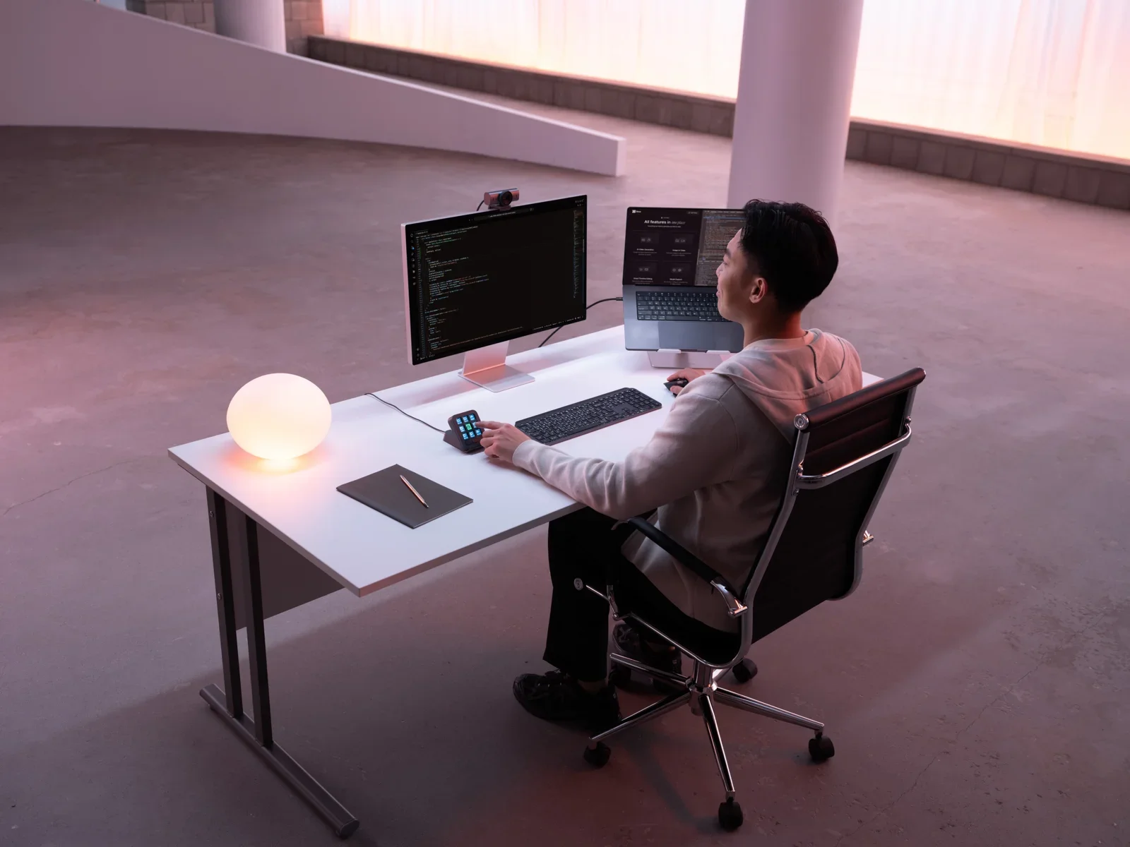 Logitech MX Keypad: pessoa usando o painel de atalhos em uma mesa com monitor, notebook e teclado.