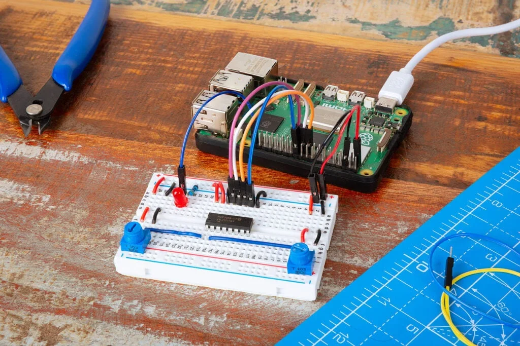 Rádio com Raspberry Pi: placa ligada a protoboard e fios sobre a bancada.